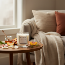 Load image into Gallery viewer, A luxury candle in a clear glass jar with cream-colored wax and a minimalist white label featuring the brand 'STACK' and scent name 'Hiding Place'.